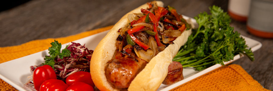 Sausage On A Bun With Caramelized Onions And Peppers